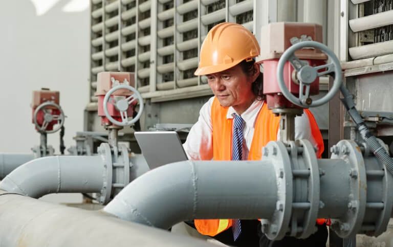 Engineer inspecting pipework at an energy facility